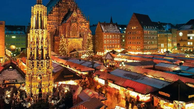Vienna Christmas market lit up at night with the Rathaus in the background