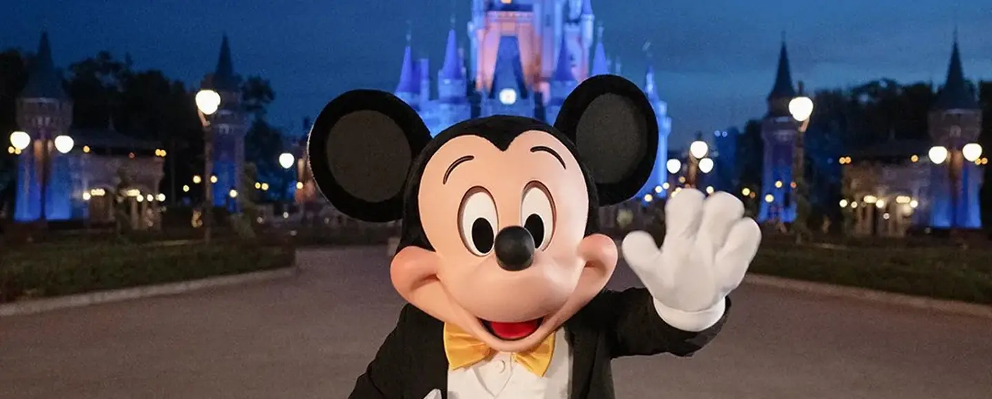 Mickey Mouse in a tuxedo smiling in front of Cinderella Castle at Magic Kingdom